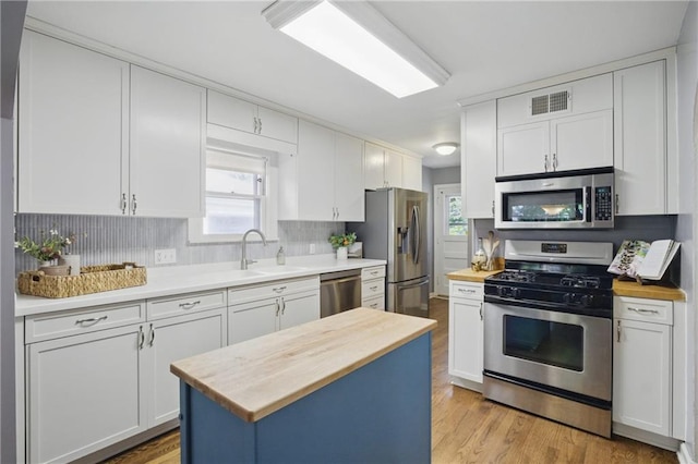 440 E 74th Ter, Kansas City, MO 64131 - kitchen featuring appliances with stainless steel finishes, wooden counters, a sink, and white cabinets