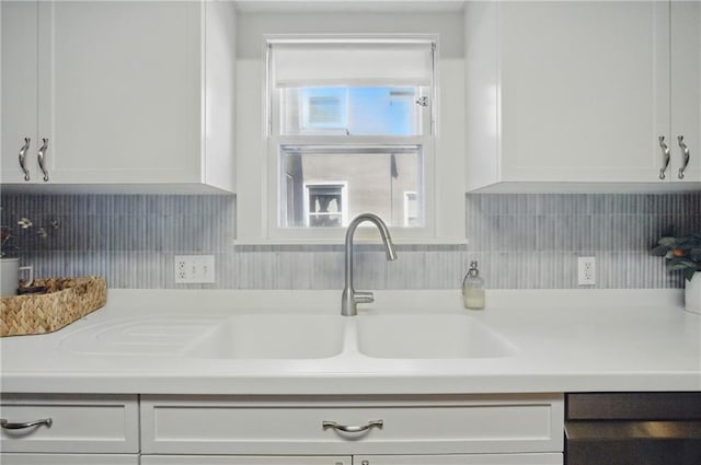 440 E 74th Ter, Kansas City, MO 64131 - kitchen with white cabinets, light countertops, backsplash, dishwasher, and a sink
