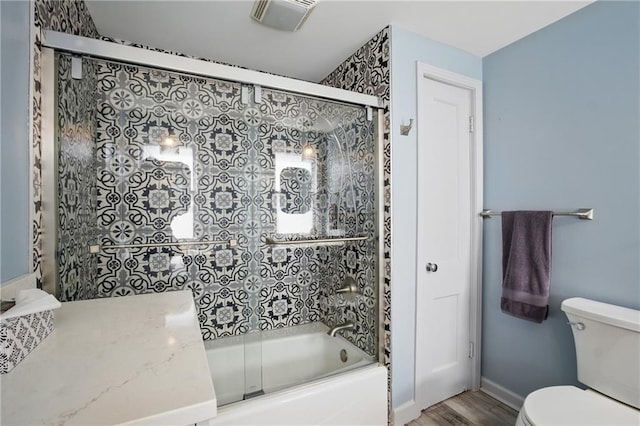 440 E 74th Ter, Kansas City, MO 64131 - full bathroom featuring toilet, bath / shower combo with glass door, wood finished floors, and baseboards