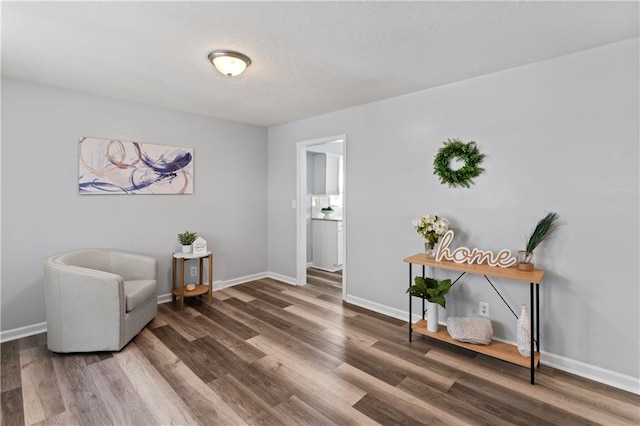 2204 S Cedar Ave, Independence, MO 64052 - living area featuring wood finished floors, baseboards, and a textured ceiling
