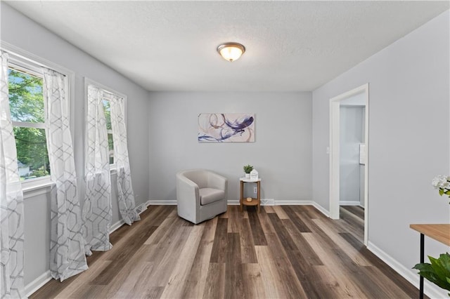 2204 S Cedar Ave, Independence, MO 64052 - sitting room with wood finished floors, baseboards, and a textured ceiling