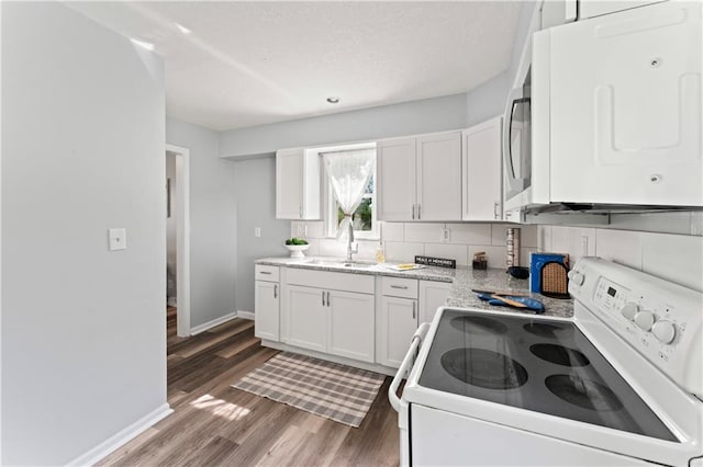2204 S Cedar Ave, Independence, MO 64052 - kitchen featuring white appliances, a sink, wood finished floors, baseboards, and white cabinets