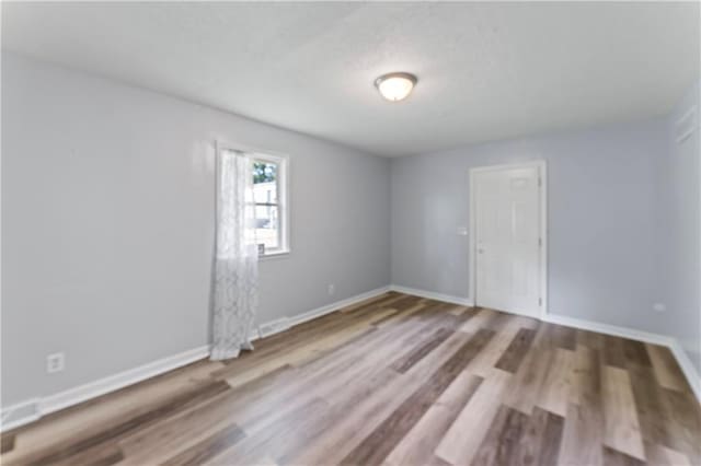 2204 S Cedar Ave, Independence, MO 64052 - unfurnished room featuring wood finished floors and baseboards