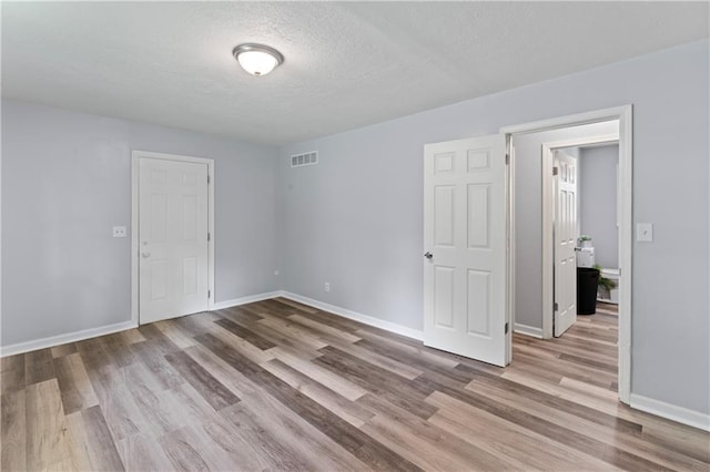 2204 S Cedar Ave, Independence, MO 64052 - empty room featuring wood finished floors, baseboards, and a textured ceiling
