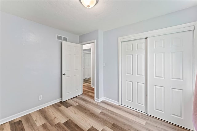 2204 S Cedar Ave, Independence, MO 64052 - unfurnished bedroom featuring baseboards, light wood-style floors, and a closet
