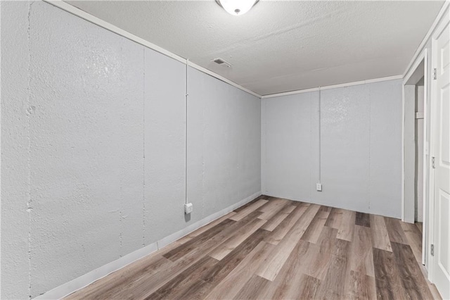 2204 S Cedar Ave, Independence, MO 64052 - unfurnished bedroom featuring wood finished floors, a textured wall, and a textured ceiling