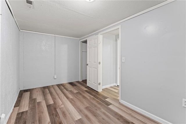 2204 S Cedar Ave, Independence, MO 64052 - unfurnished bedroom with wood finished floors, a textured ceiling, and a closet