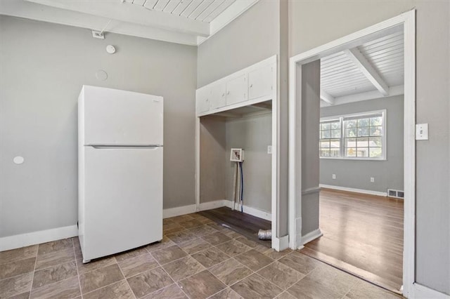 16 W 89th Ter, Kansas City, MO 64114 - kitchen with freestanding refrigerator, white cabinets, wooden ceiling with exposed beams, and baseboards