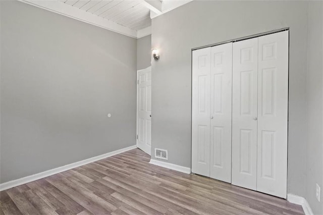 16 W 89th Ter, Kansas City, MO 64114 - unfurnished bedroom featuring wood finished floors, a closet, baseboards, and wood ceiling with exposed beams