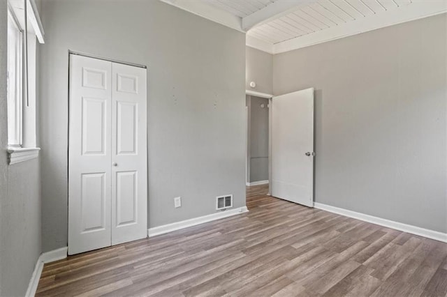 16 W 89th Ter, Kansas City, MO 64114 - unfurnished bedroom featuring wood finished floors, baseboards, a closet, and wooden ceiling with exposed beams