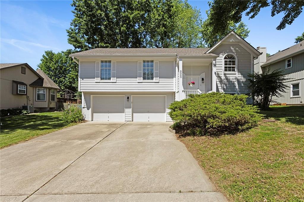 3320 Aztec Ct, Independence, MO 64057 - view of front of property with an attached garage, concrete driveway, and a front lawn