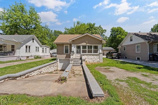 11412 E 20th St S, Independence, MO 64052 - bungalow-style home with concrete driveway, a garage, and stone siding