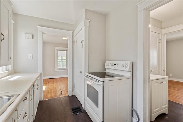 11412 E 20th St S, Independence, MO 64052 - kitchen with white electric range, dark wood-type flooring, and light countertops