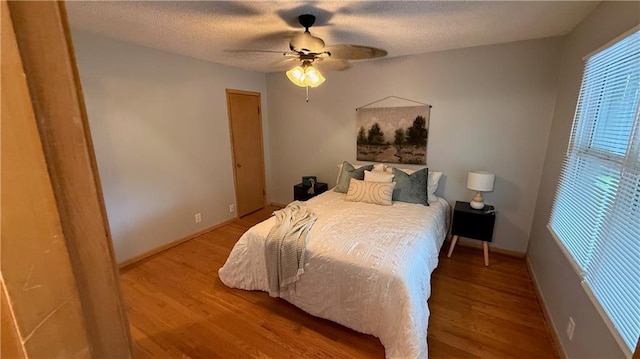 12909 E 40th St S, Independence, MO 64055 - bedroom featuring wood finished floors, ceiling fan, baseboards, and a textured ceiling