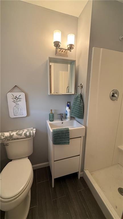 12909 E 40th St S, Independence, MO 64055 - full bath with wood tiled floors, vanity, a stall shower, toilet, and baseboards