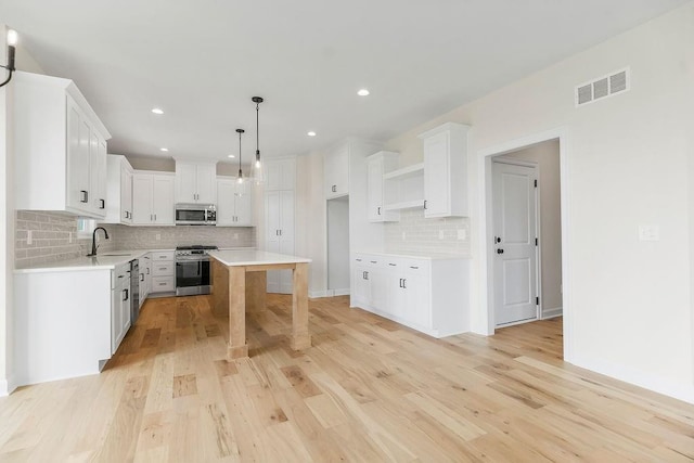 15443 W 171st Pl, Olathe, KS 66062 - kitchen featuring stainless steel appliances, decorative backsplash, light wood-style floors, recessed lighting, and white cabinetry