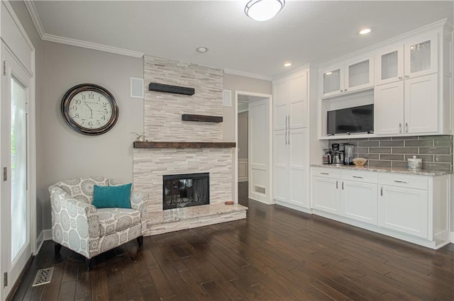 13125 Sherwood St, Leawood, KS 66209 - living area with dark wood finished floors, ornamental molding, a tiled fireplace, and recessed lighting