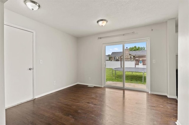 10118 E 220th St, Peculiar, MO 64078 - spare room featuring wood finished floors, baseboards, and a textured ceiling