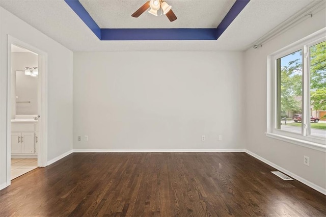 10118 E 220th St, Peculiar, MO 64078 - spare room featuring wood finished floors, ceiling fan, baseboards, and a raised ceiling
