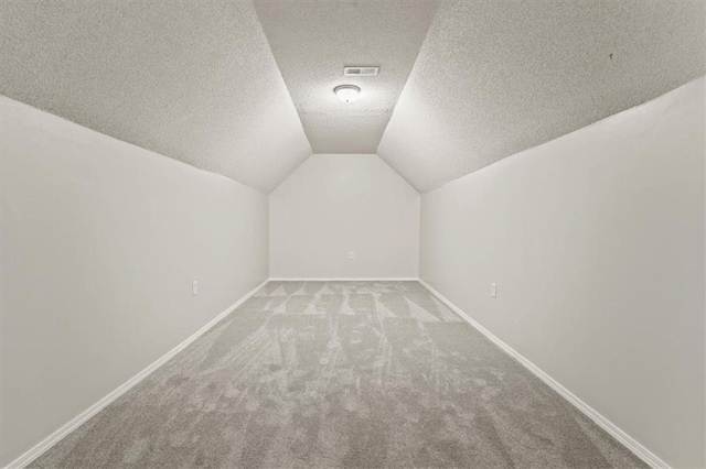 10118 E 220th St, Peculiar, MO 64078 - bonus room featuring carpet floors, vaulted ceiling, a textured ceiling, and baseboards