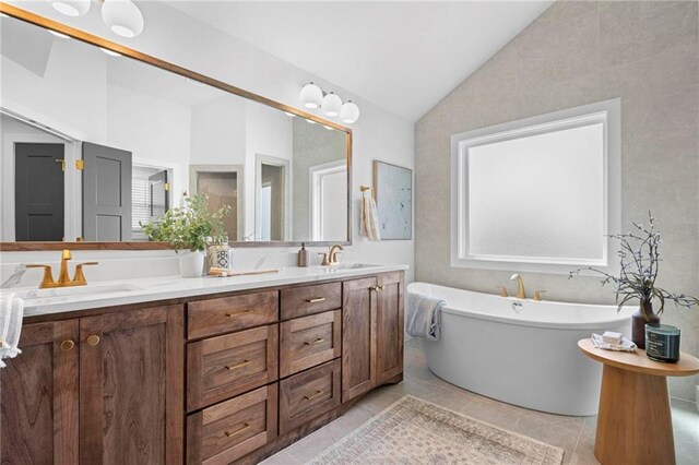8009 Round Prairie St, Shawnee, KS 66220 - bathroom featuring lofted ceiling, double vanity, a freestanding tub, and tile patterned floors