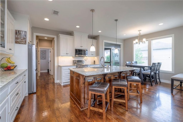 17304 S Schweiger Dr, Olathe, KS 66062 - kitchen with appliances with stainless steel finishes, a sink, a kitchen breakfast bar, white cabinets, and glass insert cabinets