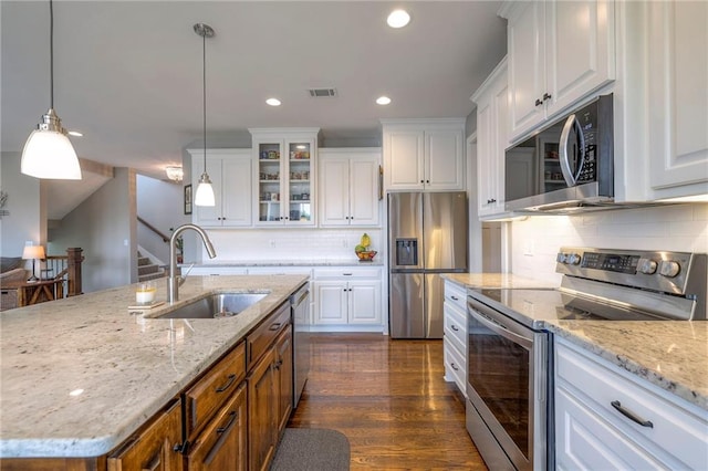 17304 S Schweiger Dr, Olathe, KS 66062 - kitchen with appliances with stainless steel finishes, a sink, white cabinetry, glass insert cabinets, and decorative backsplash