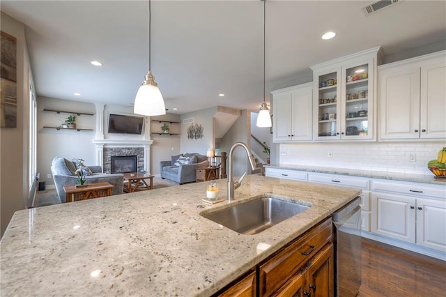 17304 S Schweiger Dr, Olathe, KS 66062 - kitchen with a sink, dishwasher, glass insert cabinets, backsplash, and a stone fireplace