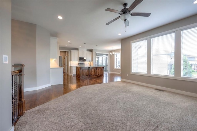 17304 S Schweiger Dr, Olathe, KS 66062 - unfurnished living room with recessed lighting, ceiling fan, dark wood-style flooring, and dark carpet