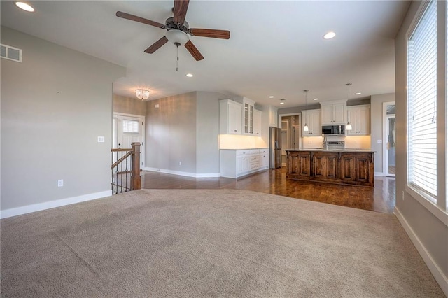17304 S Schweiger Dr, Olathe, KS 66062 - unfurnished living room featuring dark colored carpet, recessed lighting, healthy amount of natural light, and a ceiling fan