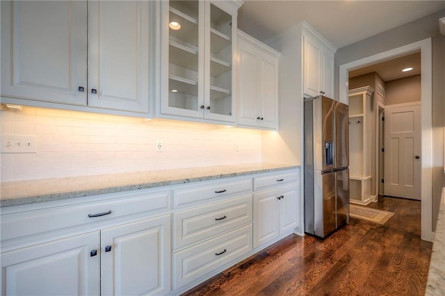 17304 S Schweiger Dr, Olathe, KS 66062 - kitchen with stainless steel fridge with ice dispenser, white cabinetry, glass insert cabinets, dark wood finished floors, and tasteful backsplash