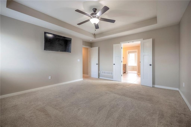 17304 S Schweiger Dr, Olathe, KS 66062 - unfurnished bedroom with a raised ceiling, light colored carpet, and a ceiling fan
