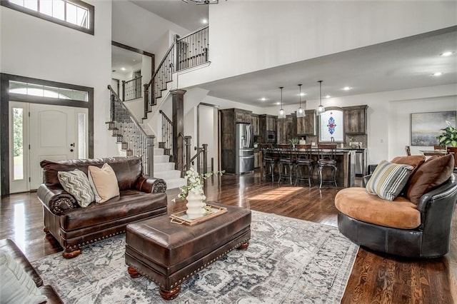 17224 Haskins St, Overland Park, KS 66062 - living area featuring dark wood finished floors, a high ceiling, stairway, and recessed lighting