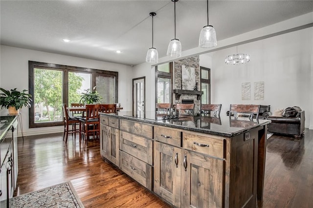 17224 Haskins St, Overland Park, KS 66062 - kitchen featuring healthy amount of natural light, dark wood-type flooring, a kitchen island, dark stone countertops, and recessed lighting