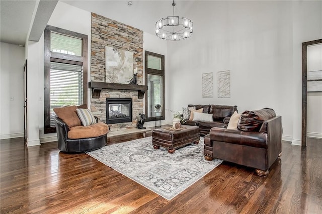 17224 Haskins St, Overland Park, KS 66062 - living room with dark wood-style floors, a towering ceiling, a stone fireplace, and a chandelier