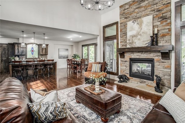 17224 Haskins St, Overland Park, KS 66062 - living area with dark wood-style floors, a stone fireplace, a chandelier, and a towering ceiling