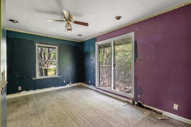 2921 E 54th St, Kansas City, MO 64130 - unfurnished room with healthy amount of natural light, baseboards, ceiling fan, and wood-type flooring