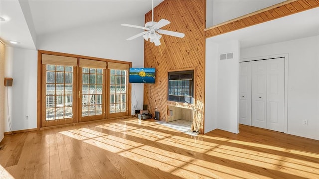 1145 Camp Branch Rd, Sunrise Beach, MO 65079 - unfurnished living room featuring high vaulted ceiling, ceiling fan, wood-type flooring, wooden walls, and baseboards