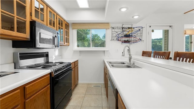 1145 Camp Branch Rd, Sunrise Beach, MO 65079 - kitchen with stainless steel appliances, a sink, brown cabinets, baseboards, and plenty of natural light