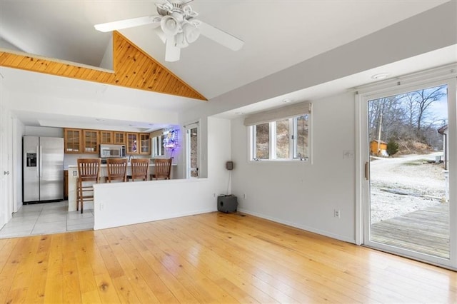 1145 Camp Branch Rd, Sunrise Beach, MO 65079 - unfurnished living room with light wood-style flooring, a ceiling fan, high vaulted ceiling, and baseboards