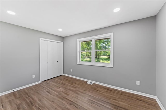 2081 Willow Ln, Excelsior Springs, MO 64024 - unfurnished bedroom featuring baseboards, wood finished floors, recessed lighting, and a closet
