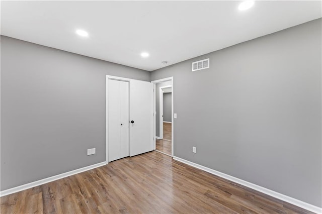 2081 Willow Ln, Excelsior Springs, MO 64024 - unfurnished bedroom featuring baseboards, wood finished floors, recessed lighting, and a closet