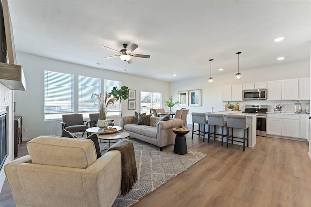 27101 E Oak View Dr, Lees Summit, MO 64086 - living room featuring light wood-style flooring, a ceiling fan, recessed lighting, and a glass covered fireplace