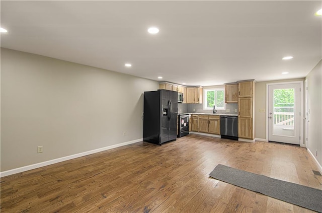 5539 NW Adrian Ave, Houston Lake, MO 64151 - kitchen with stainless steel appliances, wood finished floors, light countertops, recessed lighting, and backsplash