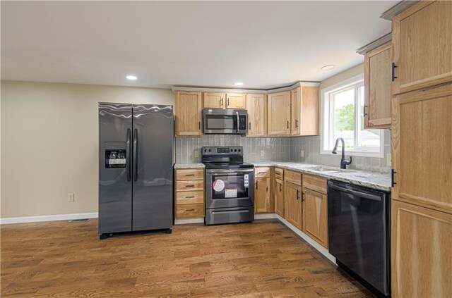 5539 NW Adrian Ave, Houston Lake, MO 64151 - kitchen with stainless steel appliances, light brown cabinetry, dark wood finished floors, decorative backsplash, and light stone counters