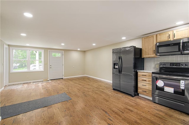 5539 NW Adrian Ave, Houston Lake, MO 64151 - kitchen with stainless steel appliances, light wood-style flooring, light brown cabinetry, recessed lighting, and light countertops