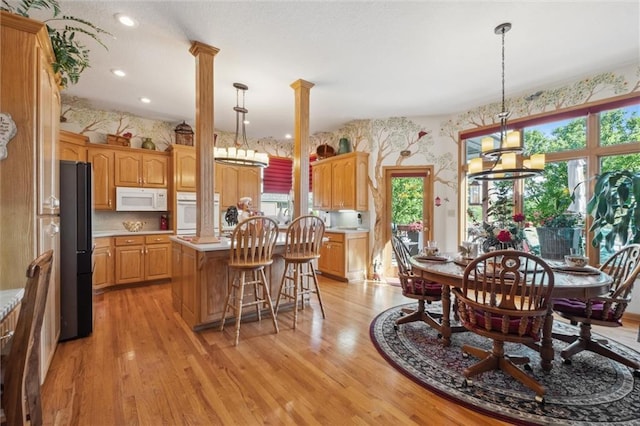 15471 Cedar Ln, Basehor, KS 66007 - dining area featuring wallpapered walls, decorative columns, light wood-style floors, and recessed lighting
