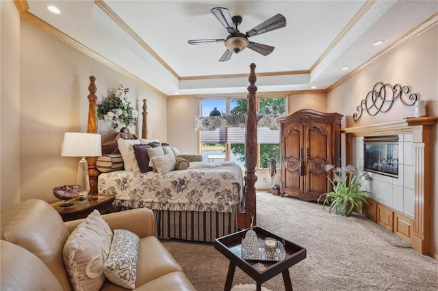 15471 Cedar Ln, Basehor, KS 66007 - carpeted bedroom with a tray ceiling, ornamental molding, a glass covered fireplace, ceiling fan, and recessed lighting