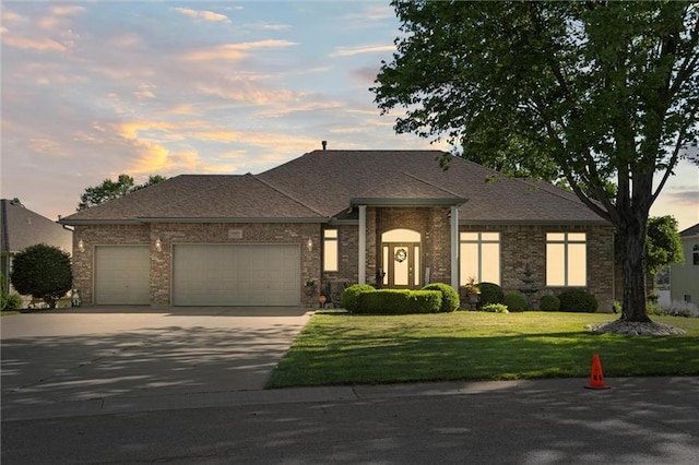15471 Cedar Ln, Basehor, KS 66007 - view of front of house with an attached garage, concrete driveway, a lawn, and brick siding