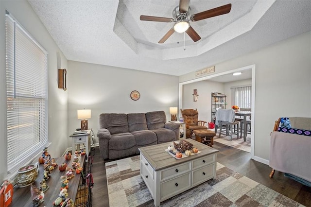 3620 S Northern Blvd, Independence, MO 64052 - living area with wood finished floors, a ceiling fan, a raised ceiling, a textured ceiling, and baseboards